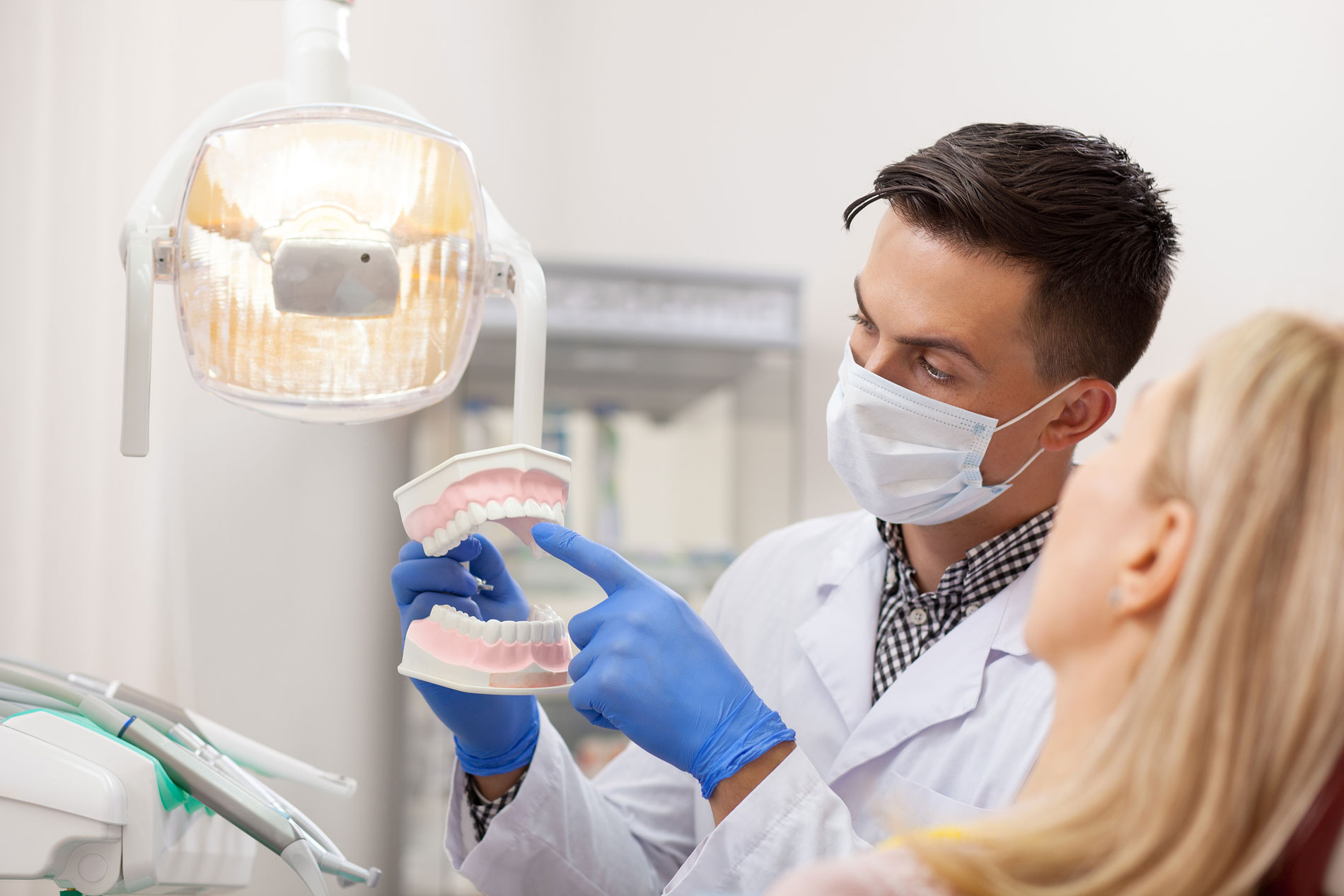 bigstock-Male-Dentist-Explaining-His-Fe-401498615